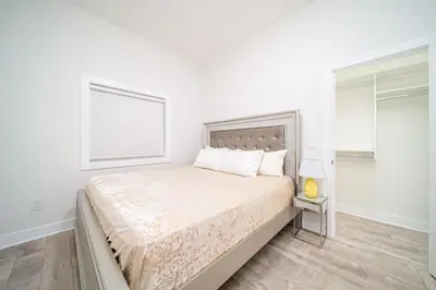 a white bedroom with a bed and a window at Sun suite in Surrey