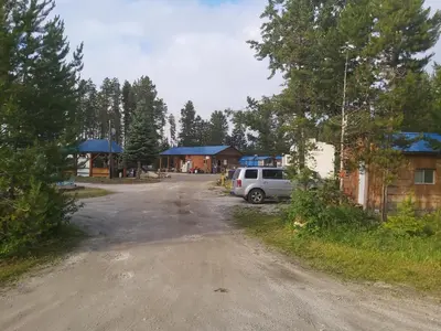 a dirt road with a van parked in front of a building at Blue River Campgrounds & Cabin-public washroom in Blue River