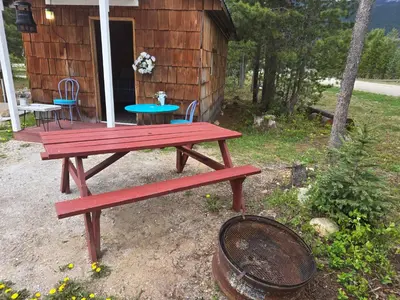 a picnic table in front of a cabin at Blue River Campgrounds & Cabin-public washroom in Blue River