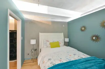 a bedroom with a bed with a blue wall at Harbourview Executive Condo by EMR Vacation Rentals in Victoria