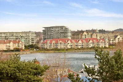 a city with houses and a river with buildings at Harbourview Executive Condo by EMR Vacation Rentals in Victoria