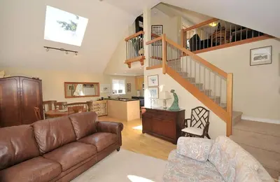 a living room with a couch and a staircase at Heron View Cottage by EMR Vacation Rentals in Sidney