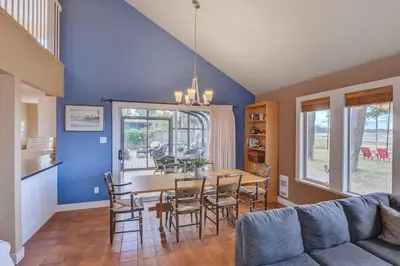 a living room with a table and chairs and a couch at Kye Bay Beach House by EMR Vacation Rentals in Comox