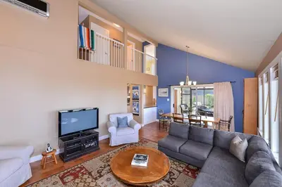 a living room with a couch and a tv at Kye Bay Beach House by EMR Vacation Rentals in Comox