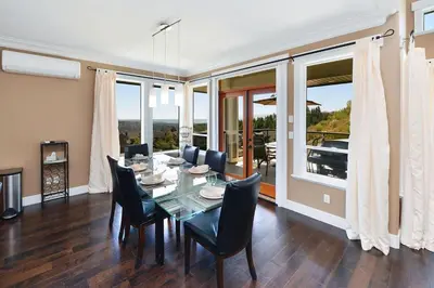 a dining room with a glass table and chairs at Nature's Gate Executive Estate by EMR Vacation Rentals in Victoria