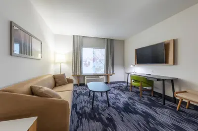 a living room with a couch and a table and a desk at Fairfield Inn & Suites by Marriott Salmon Arm in Salmon Arm