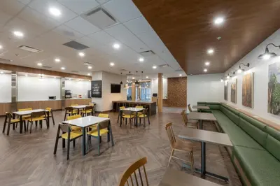 a restaurant with tables and chairs and a green couch at Fairfield Inn & Suites by Marriott Salmon Arm in Salmon Arm