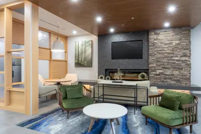 a living room with chairs tables and a tv at Fairfield Inn & Suites by Marriott Salmon Arm in Salmon Arm