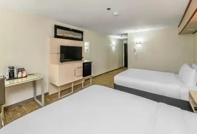 a hotel room with two beds and a flat screen tv at Quality Inn Sunshine Suites in Terrace