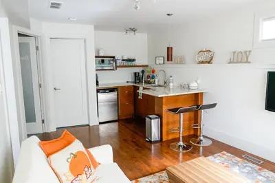 a living room with a couch and a kitchen at Studio on Capri in Calgary
