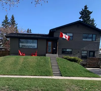 a house with a canadian flag in front of it at Studio on Capri in Calgary