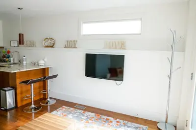 a living room with a flat screen tv on a wall at Studio on Capri in Calgary