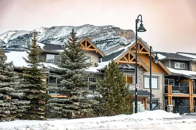 a house in the snow with a mountain at Copperstone Resort in Dead Man's Flats