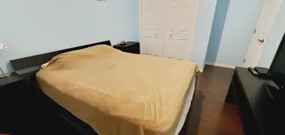 a small bedroom with a bed with a yellow blanket at Parson Creek Cozy suite in Fort McMurray