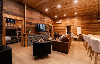 a living room with wooden walls and a couch and a table at Boulder Mountain Resort in Revelstoke