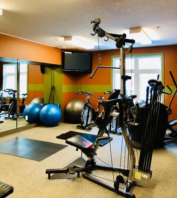 a gym with bikes and exercise equipment in a room at Luxurious One Bedroom Suite for a Larger Family 162 in Canmore