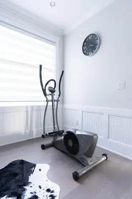 a room with a gym with a treadmill and a clock at 5-Star Luxury and comfortable home in New Westminster
