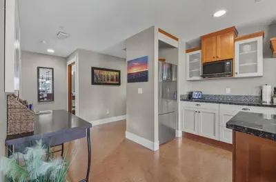 a kitchen with white cabinets and a counter top at Sunset Ridge - Luxurious Corner Condo - Spectacular Mt Views with open Pool! in Canmore