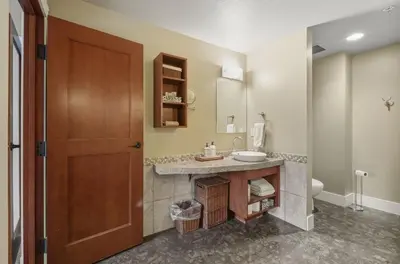 a bathroom with a sink and a toilet at Sunset Ridge - Luxurious Corner Condo - Spectacular Mt Views with open Pool! in Canmore