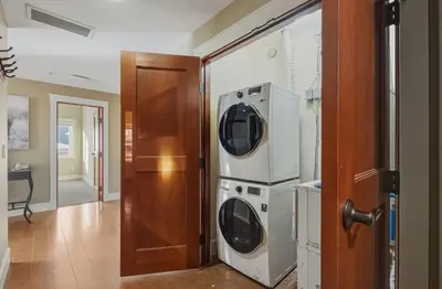 two washers and a dryer in a room at Sunset Ridge - Luxurious Corner Condo - Spectacular Mt Views with open Pool! in Canmore