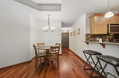 a kitchen and dining room with a table and chairs at Beautiful Peak Vista - 2BR w Stunning Mt Views in Canmore