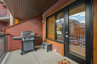 a grill on a patio next to a house at Beautiful Peak Vista - 2BR w Stunning Mt Views in Canmore