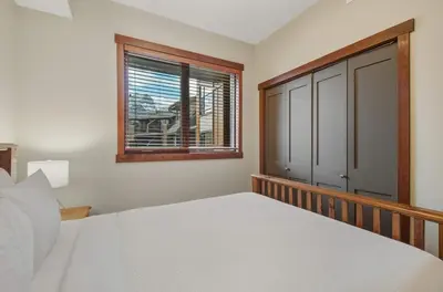 a bedroom with a bed and a window at Beautiful Peak Vista - 2BR w Stunning Mt Views in Canmore