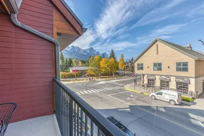 a balcony with a view of a street and a building at Rundle Rise - Spacious Condo Steps from Main Street in Canmore