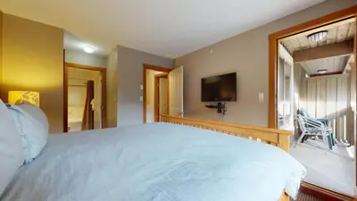 a bedroom with a large bed and a television at 2BR in Symphony, Whistler Village, Complex Hot Tub, Gas Fireplace, Parking, Gondola Shuttle in Whistler
