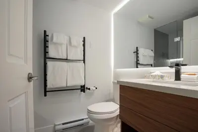 a white bathroom with a toilet and a sink at 1BR in Northstar, Village Location, Gas Fireplace, Shared Hot Tub, Ski Storage in Whistler