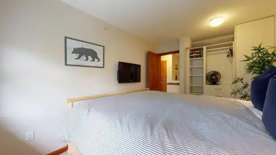 a bedroom with a bed with a bear picture on the wall at 2BR in Northstar, Whistler Village, Fireplace, Hot Tub, Central Location, Ski Storage in Whistler