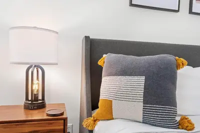 a bed with a pillow and a lamp on a table at 2BR in The Aspens, Ski In, Ski Out, Pool and Hot Tub, Gas Fireplace, Ski Valet, Gym in Whistler