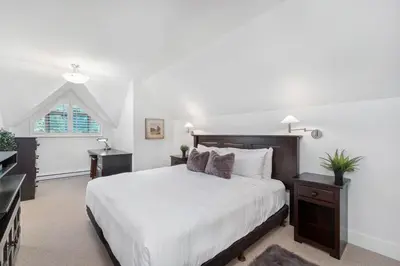 a white bedroom with a large bed and a window at 3BR in Gleneagle, Soaker Tub with Skylight, Wood Burning Fireplace, Spacious Layout in Whistler