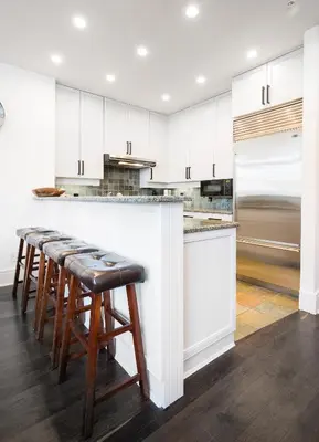 a kitchen with white cabinets and bar stools at 3BR Luxury Home in Taluswood, Hot Tub, Ski In, Ski Out, Two-Car Garage, Village Parking in Whistler