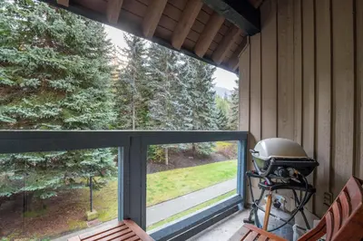 a screened in porch with a large window and a grill at 3BR in Foxglove, Wood Burning Fireplace, Mudroom, Near Gondola, Parking in Whistler