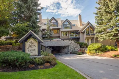 a large house with a sign in the front yard at 3BR in Foxglove, Wood Burning Fireplace, Mudroom, Near Gondola, Parking in Whistler