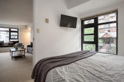 a bedroom with a bed and a tv on the wall at 1BR in Carleton Lodge, Unbeatable Mountain Base Location, Ski In, Ski Out, Free Parking in Whistler