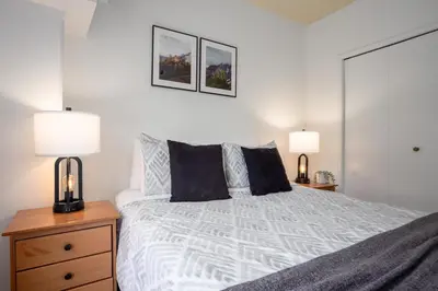 a bedroom with a large bed with two lamps at 1BR in Carleton Lodge, Unbeatable Mountain Base Location, Ski In, Ski Out, Free Parking in Whistler