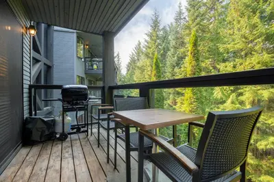 a deck with a table and chairs and a grill at 2BR in Powderhorn, Near Blackcomb, Double-Sided Fireplace, Rooftop Hot Tub, Parking in Whistler