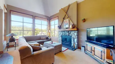 a living room with a couch and a tv and a fireplace at 3BR in Blackcomb Greens, Wood Burning Fireplace, Complex Hot Tub, Parking, Mountain Views in Whistler