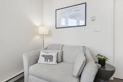 a living room with a couch with a pillow on it at 3BR in Tyndall Stone Lodge, Village Location with Olympic Plaza Views, Fireplace, Hot Tub in Whistler