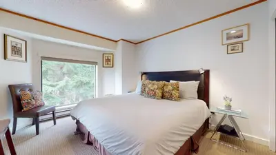 a bedroom with a large bed and a window at 2BR plus Den in The Gables, Unbeatable Location Near Gondolas, Private Balcony, Secure Parking in Whistler