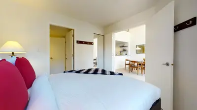 a bedroom with a white bed with red pillows at 1BR plus Loft in Tyndall Stone Lodge, Village Location, Pool and Hot Tub, Private Balcony in Whistler