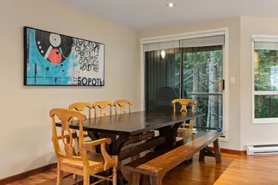 a dining room with a wooden table and chairs at 4BR in Blueberry Hill Estates, Lake View, Tranquil Setting, Gourmet Kitchen, Family Sized in Whistler