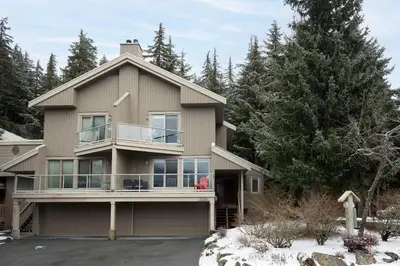 a house with a wrap around porch in the snow at 4BR in Blueberry Hill Estates, Lake View, Tranquil Setting, Gourmet Kitchen, Family Sized in Whistler