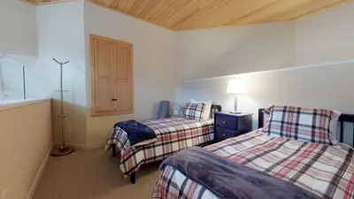 a bedroom with two beds and a cabinet in it at 1BR plus Loft in Glacier Lodge, King Bed, Near Gondola, Private Balcony, Free Ski Valet in Whistler