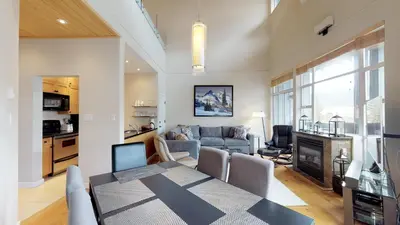 a kitchen and a living room with a table and a couch at 1BR plus Loft in Glacier Lodge, King Bed, Near Gondola, Private Balcony, Free Ski Valet in Whistler