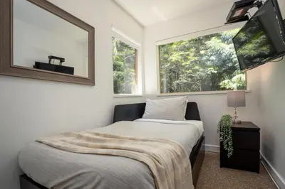 a small bedroom with a bed and a window at 2BR plus Loft in Valhalla, Village Location, Covered Patio, King Bed, Hot Tub in Whistler