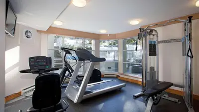 a room with a gym with a treadmill and a window at 2BR plus Den in Woodrun, True Ski In, Ski Out, Heated Floors, Pool and Hot Tub, King Ensuite in Whistler