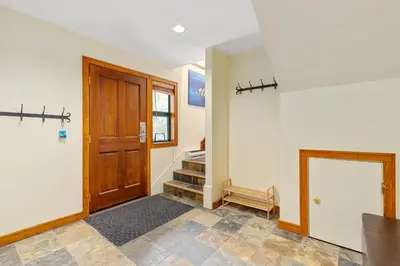 a hallway with a wooden door and a staircase at 3BR in The Woods, Private Hot Tub, Wood Burning Fireplace, King Ensuite, Private Garage in Whistler